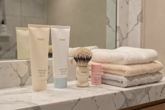 Produits de soins et crèmes dépilatoires disposés sur un comptoir en marbre dans une salle de bain moderne