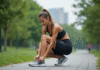 Femme en tenue de sport attachant ses chaussures dans un parc urbain
